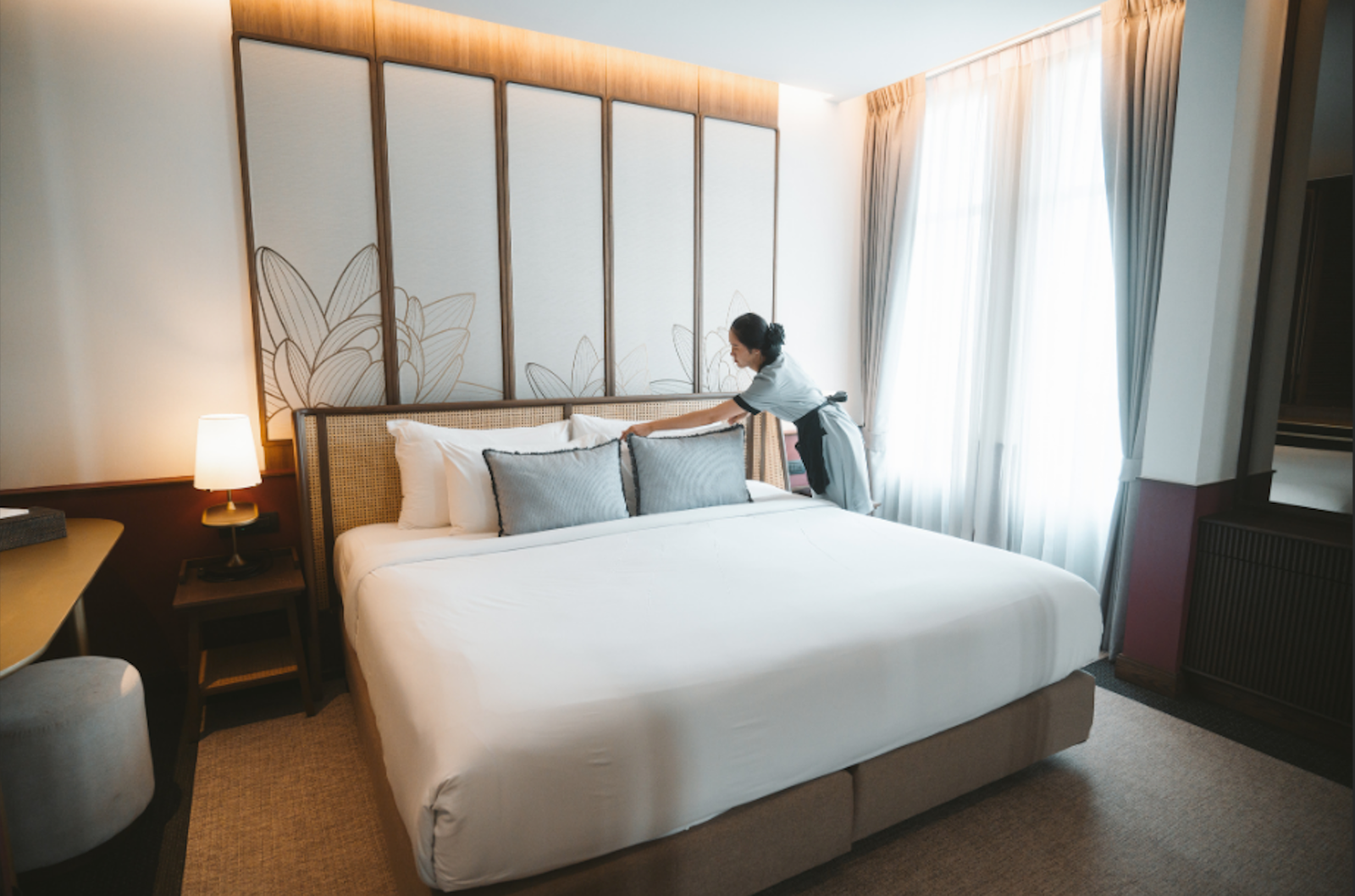 Une femme de chambre nettoie et prepare une chambre d